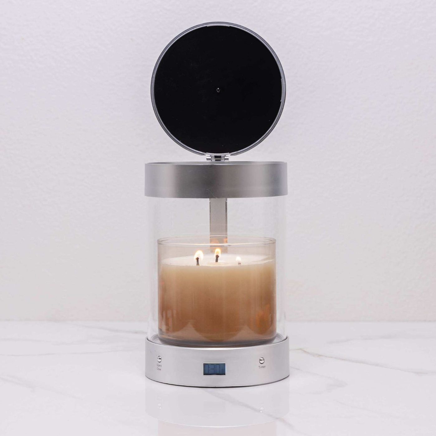 ALEC with its lid open over a lit three-wick jar candle