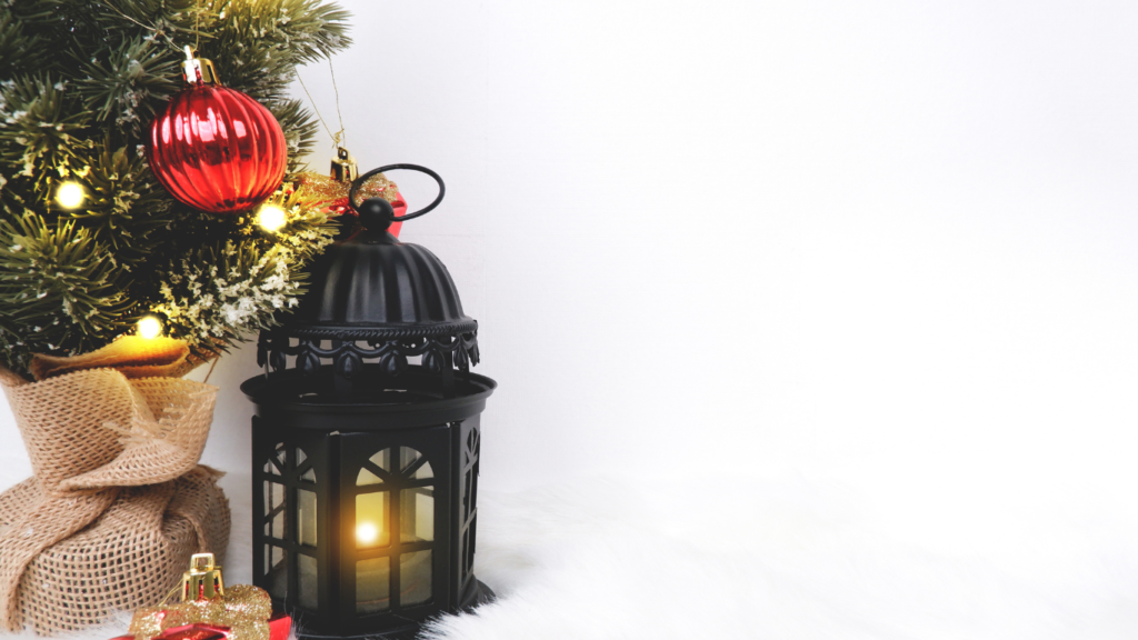 A Christmas tree with red ornaments, a glowing black lantern, and wrapped gifts on a snowy backdrop.