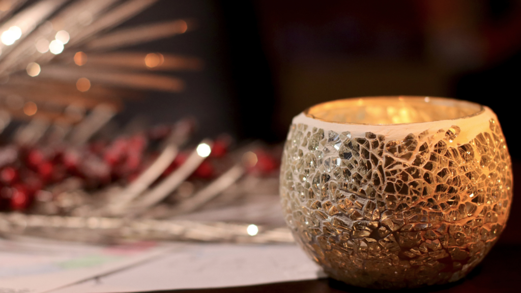 A cracked glass candle holder glows warmly